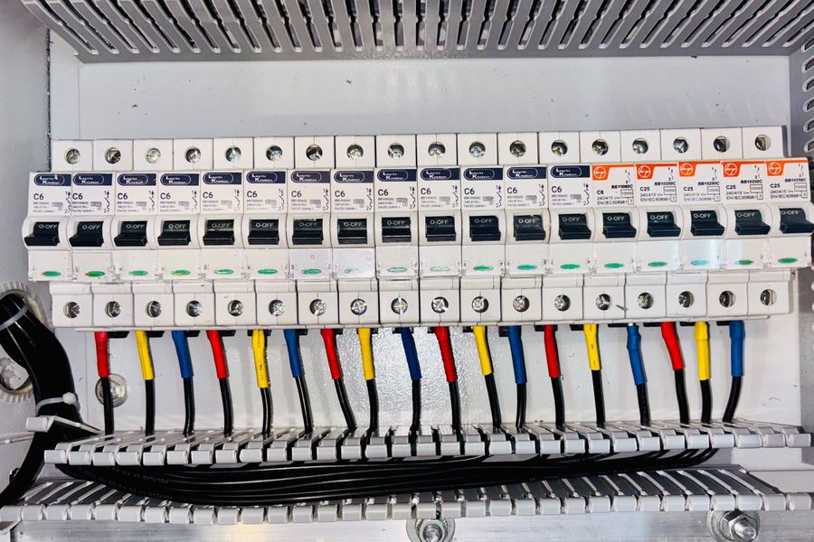 Tablero eléctrico de distribución con breakers y cableado ordenado por colores